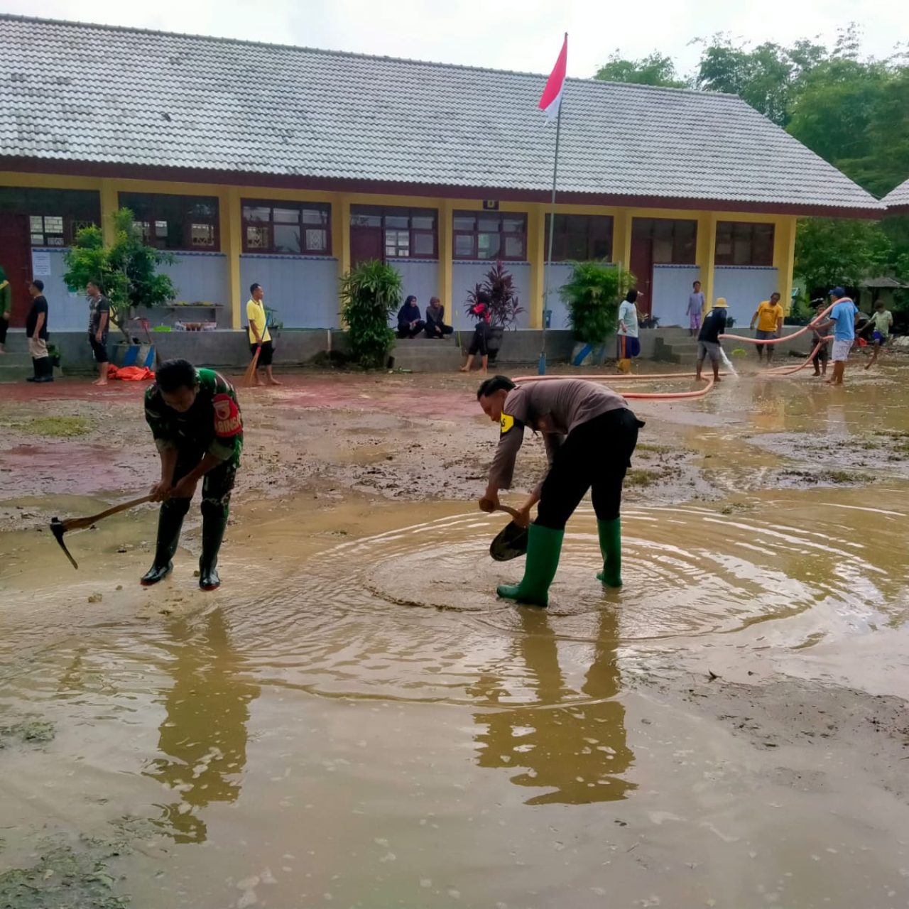 Gotong Royong Polisi dan TNI bersama Warga Bersihkan Sisa Meterial Banjir di Tuban